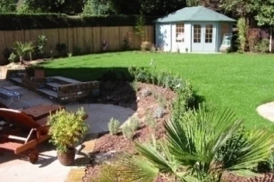 Curved garden borders and lawn leading to a summerhouse